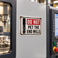 Illustrative mockup of Do Not Pet the End Mills magnet on a CNC machine enclosure.